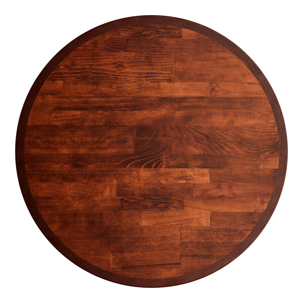A Lancaster Table & Seating Mid-Century round wooden table top with a mahogany finish.