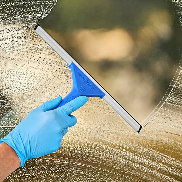 A hand wearing a blue glove using an Ettore 12" squeegee to clean a window.