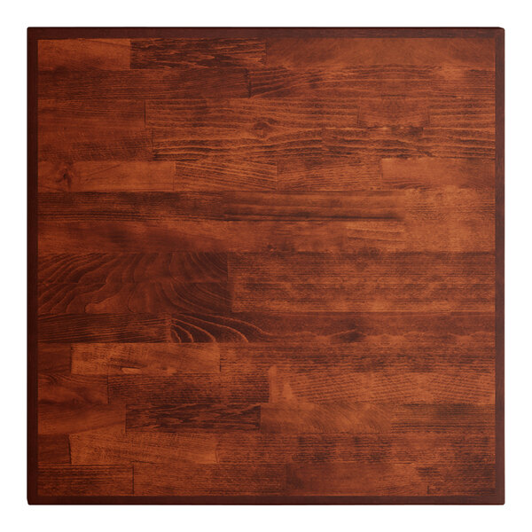 A close up of a Lancaster Table & Seating butcher block table top with a mahogany finish.