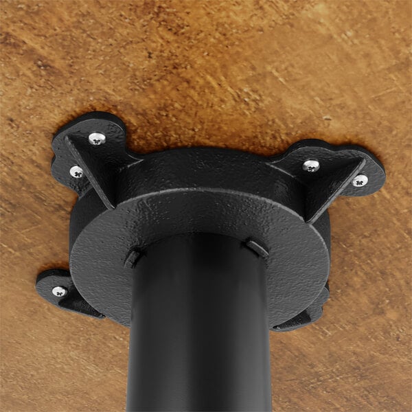 A Lancaster Table & Seating round wood table with cast iron base plate.