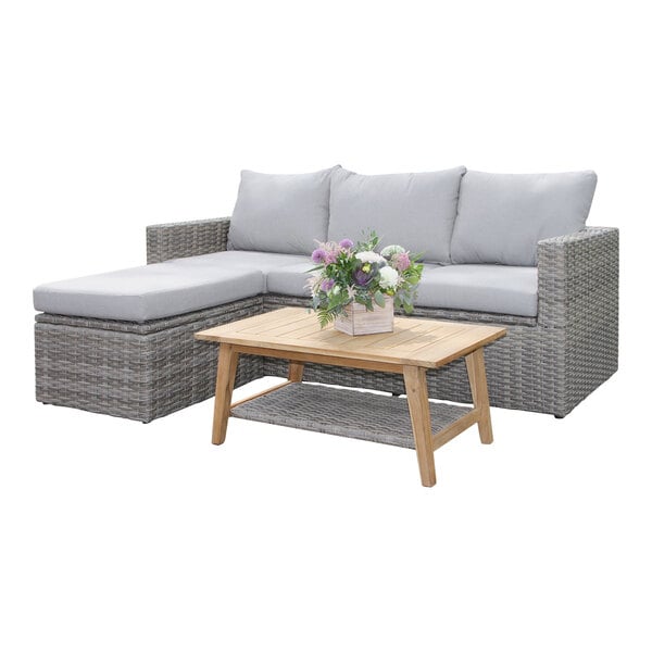 An Outdoor Interiors teak and wicker sectional sofa with a coffee table on a white background.