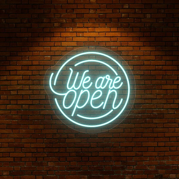 An ice blue neon "We Are Open" sign on a brick wall.