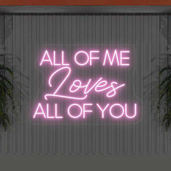 A pink Crazy Neon "All Of Me Loves All Of You" LED neon sign on a wall.