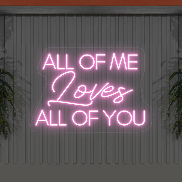 A pink Crazy Neon LED sign that says "All Of Me Loves All Of You" on a grey wall.