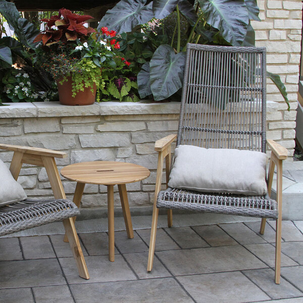 A wooden table and chair on a patio.