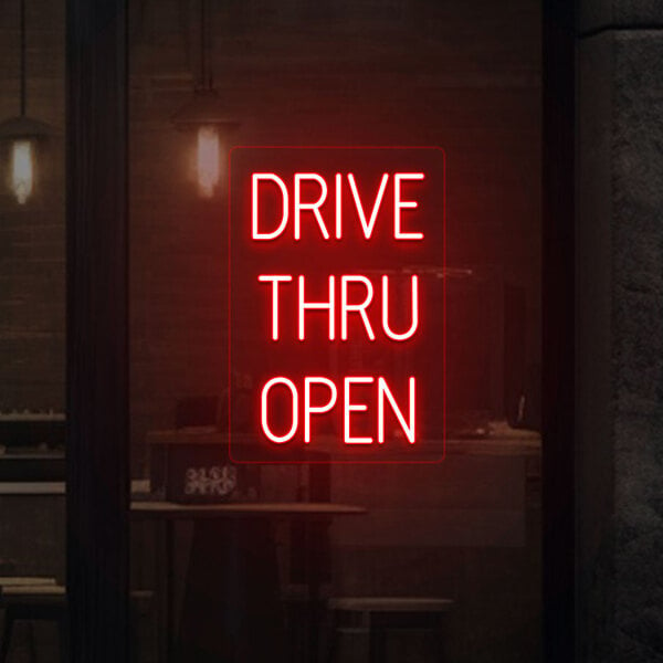 A red neon sign with white letters that says "Drive Thru Open" on a wall.