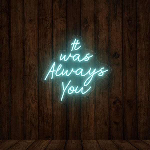 A Crazy Neon ice blue LED "It Was Always You" sign on a wood wall.