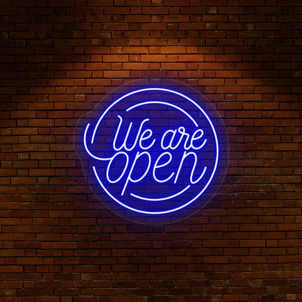 A Crazy Neon blue "We Are Open" LED sign on a brick wall.