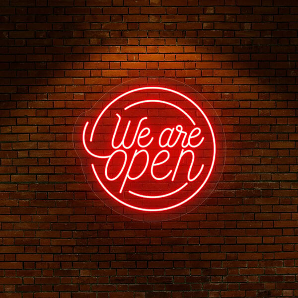 A Crazy Neon red LED "We Are Open" sign on a brick wall.