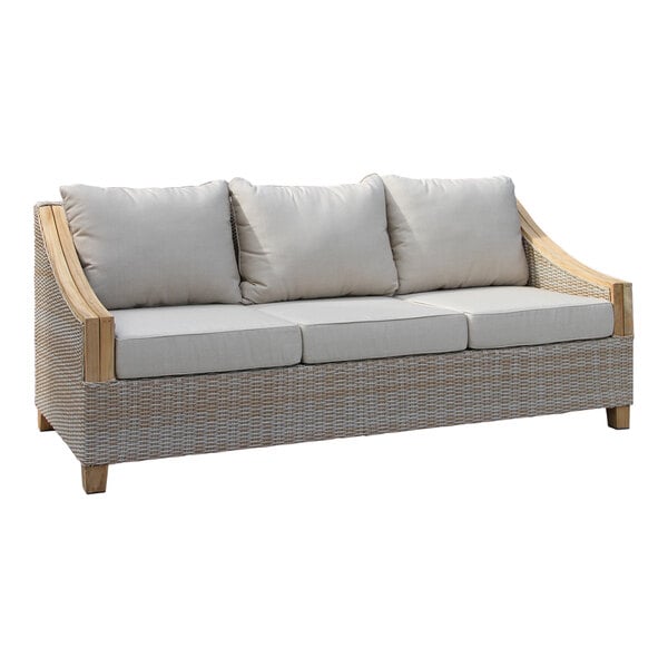 An Outdoor Interiors teak and ash wicker sofa with white cushions on it.