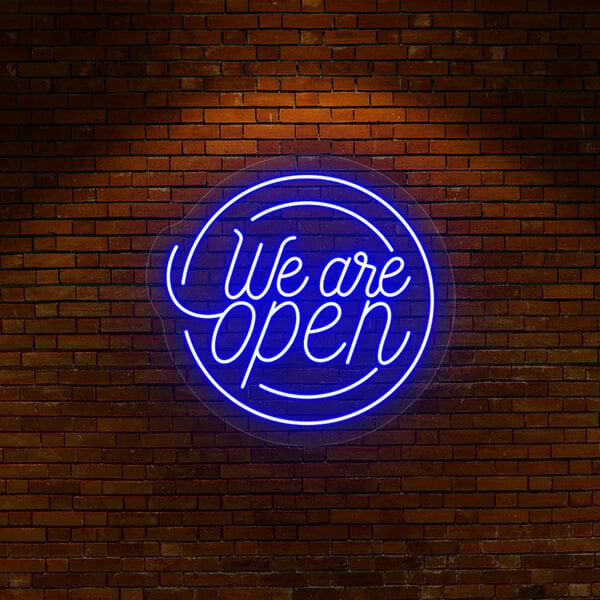 A Crazy Neon blue LED "We Are Open" sign on a brick wall.