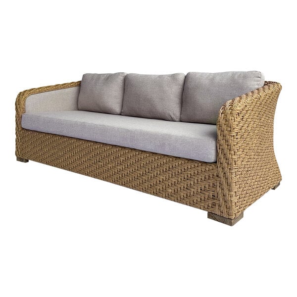 An Outdoor Interiors Sahara wicker sofa with grey cushions on it.