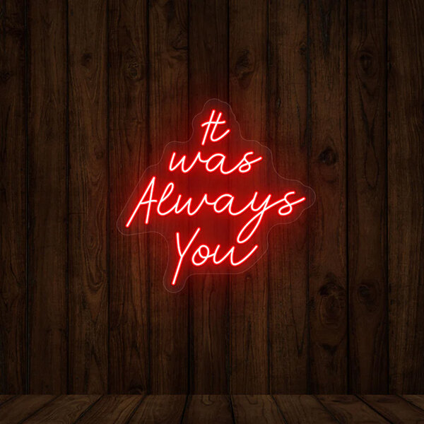 A red neon Crazy Neon "It Was Always You" sign on a wood wall.