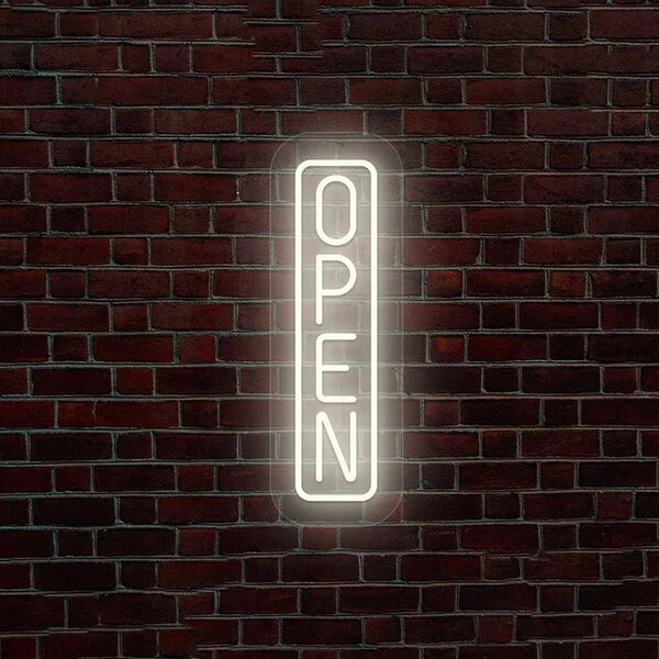 A lit up "Open" sign on a grey brick wall.