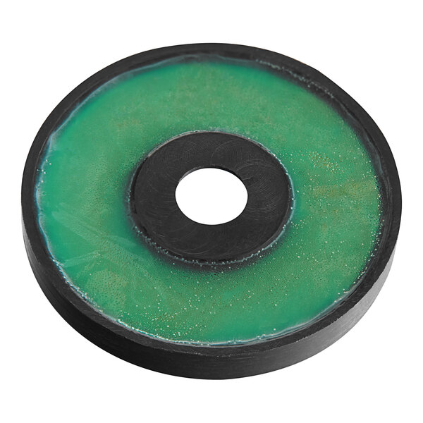 A green and black circular Estella magnet with a hole in the center.