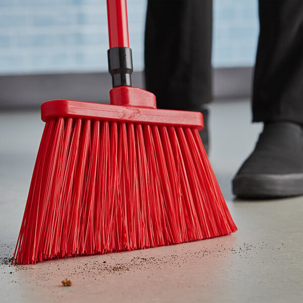 A red broom sweeping the floor.