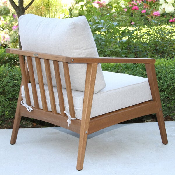 An Outdoor Interiors eucalyptus wood arm chair with a white cushion on it.