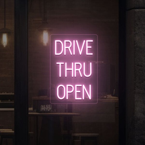 A pink neon sign that says "Drive Thru Open"