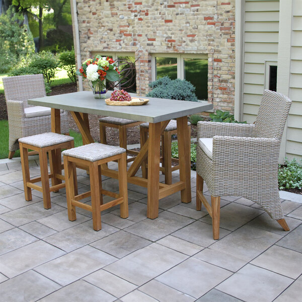 An Outdoor Interiors wicker chair with a white cushion on a patio.
