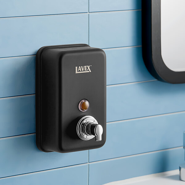 A close-up of a matte black Lavex manual foaming soap dispenser.