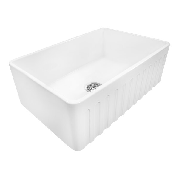 A white Ruvati Fiamma farmhouse sink with a drain.