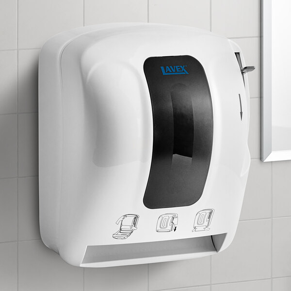 A white Lavex lever-activated paper towel dispenser on a tile wall.