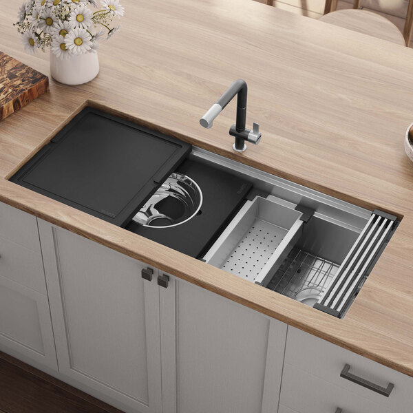 A Ruvati stainless steel workstation sink in a wooden counter.