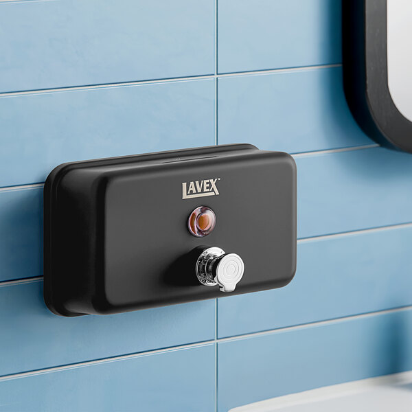 A black Lavex foam soap dispenser on a white wall.