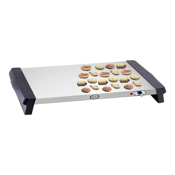 A Cadco electric countertop warming shelf with small pizzas on it.