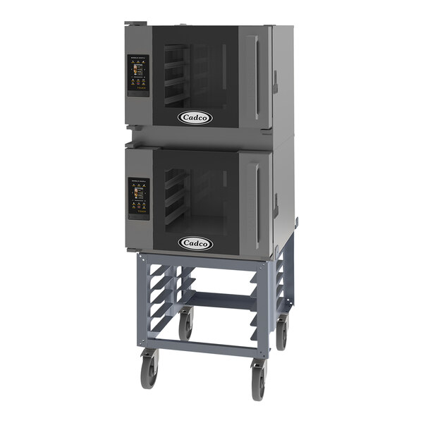 Two Cadco Bakerlux countertop convection ovens on a stand with wheels.