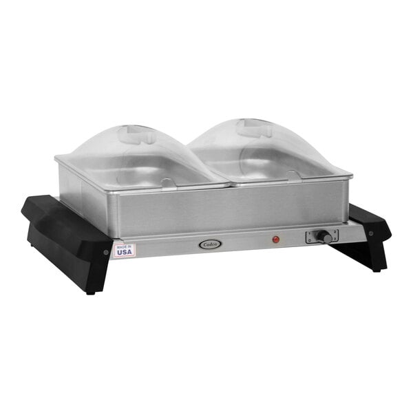 A silver and black Cadco double electric countertop buffet server with clear lids holding two stainless steel trays.