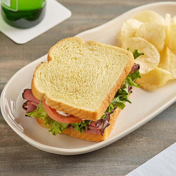 A sandwich made with Martin's Famous Sliced Potato Bread on a plate with potato chips.