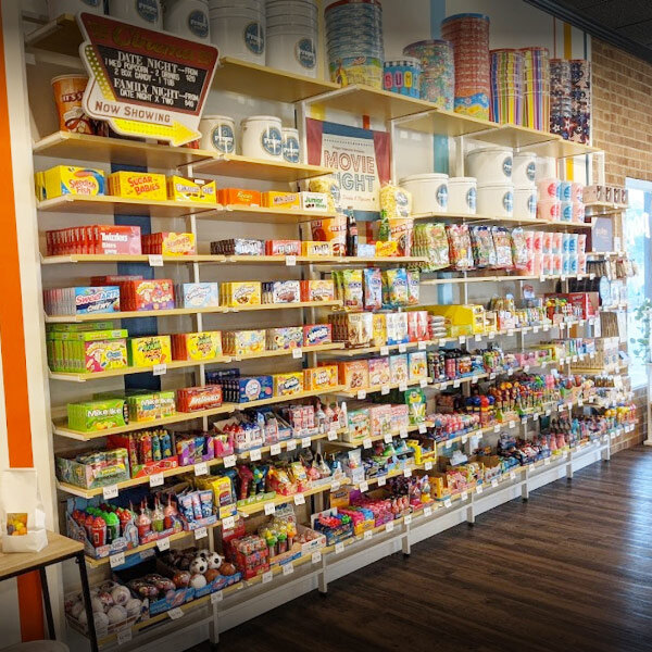 A store with shelves filled with various items, including clothing on UDIZINE Vertik retail clothing display shelves.