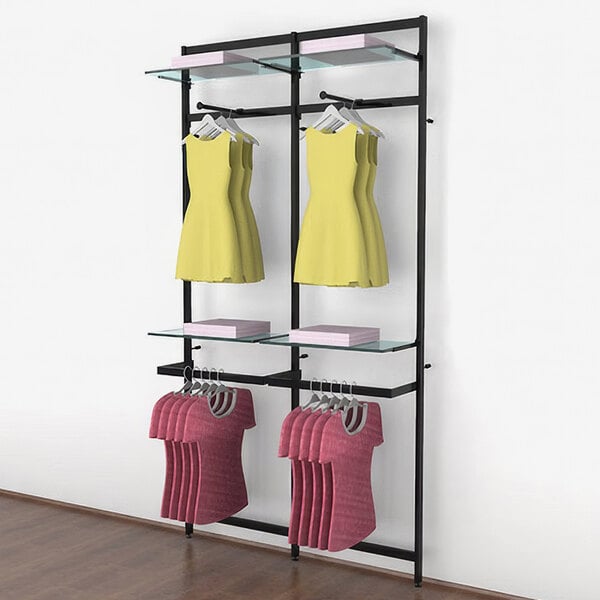 A black Udizine wall-mounted retail clothing display with faceouts and hanging rails holding yellow and pink clothes.