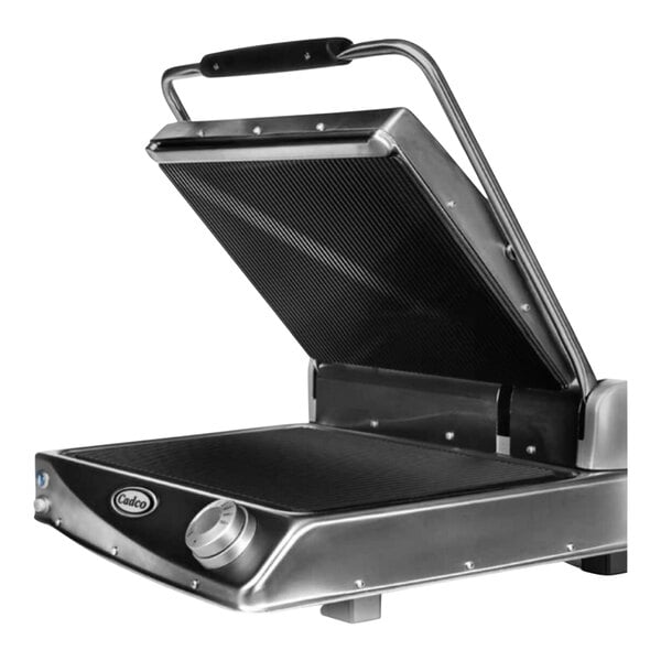 A black and silver Cadco Jumbo Panini Grill with grooved plates.