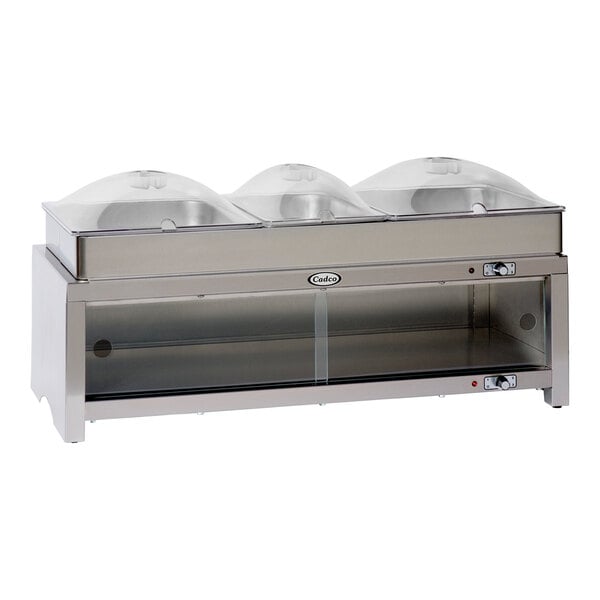 A silver Cadco countertop food warmer with clear dome lids on a counter.