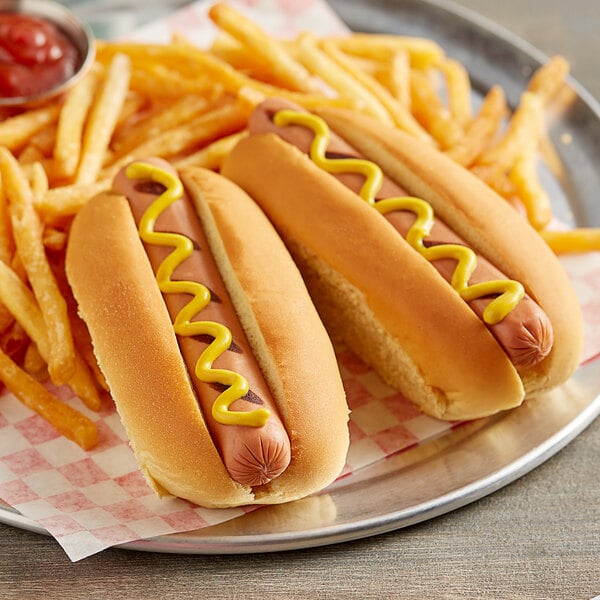 Two Martin's Famous hot dogs with mustard on potato rolls with french fries.