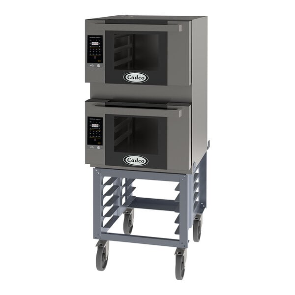 A large grey Cadco Bakerlux countertop convection oven stand with two ovens on wheels.