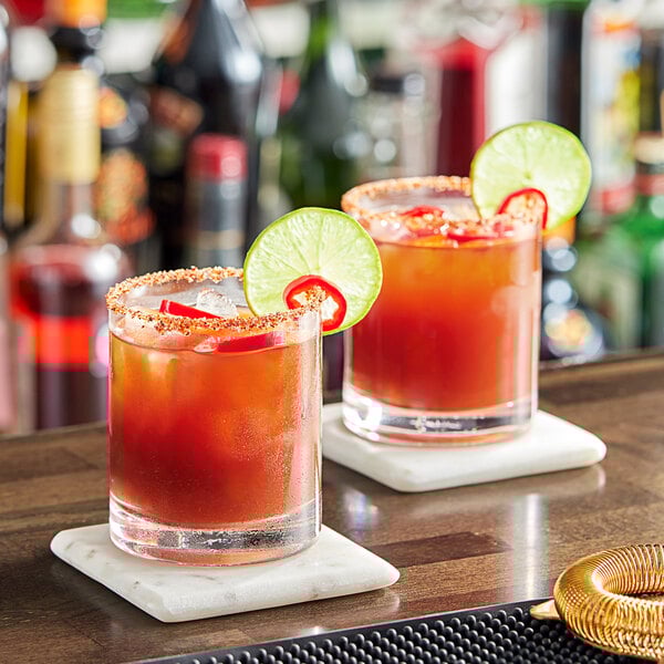 Two glasses of Zing Zang Michelada drinks on a bar.