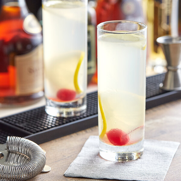 A cocktail in an Acopa highball glass with a cherry.