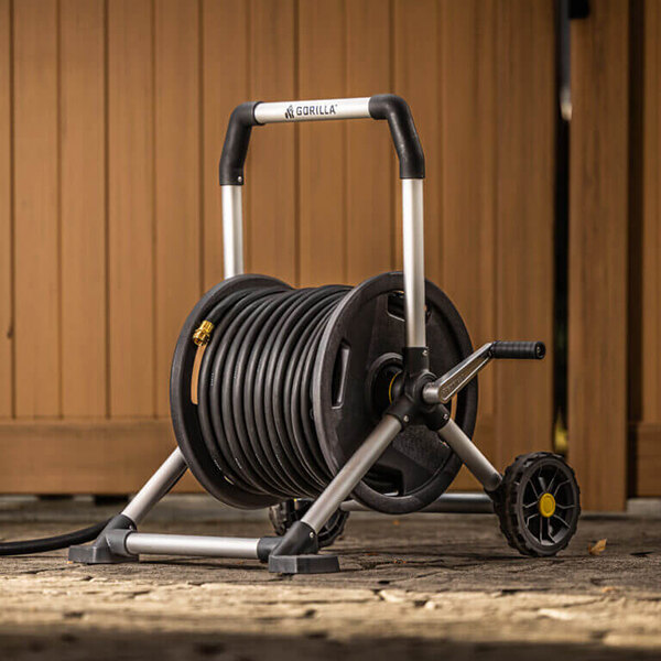 A Gorilla mobile hose reel cart with a black hose on it.
