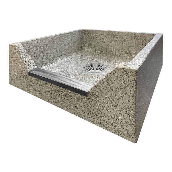 A square stone mop sink basin with a stainless steel threshold cap and drain.