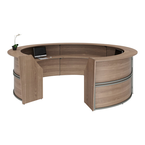 A walnut laminate curved reception desk with a laptop on it.