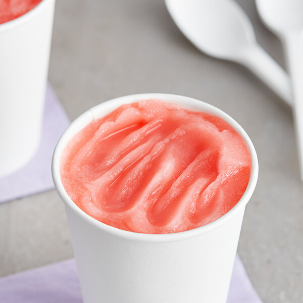 A bowl of pink I. Rice water ice on a white surface.