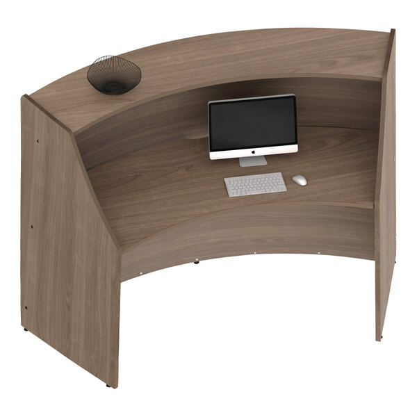 A Correll walnut laminate curved reception counter desk with a computer and keyboard.