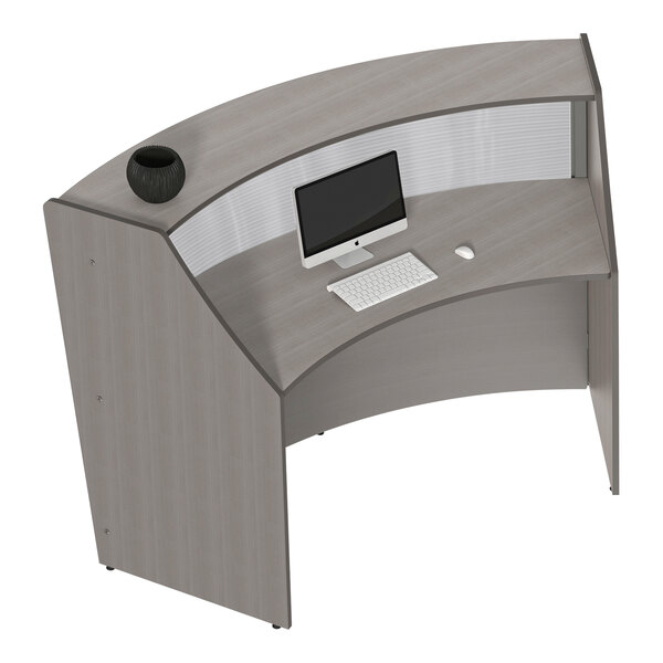 A Correll curved reception desk with a computer and keyboard on it.