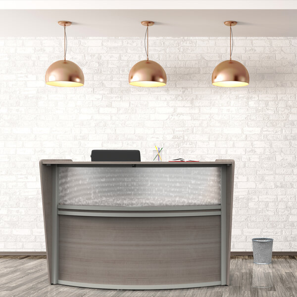 A Correll curved ash laminate reception desk with pendant lights above.