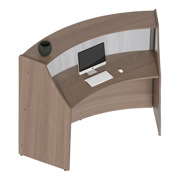 A Correll walnut curved reception desk with a computer and keyboard.
