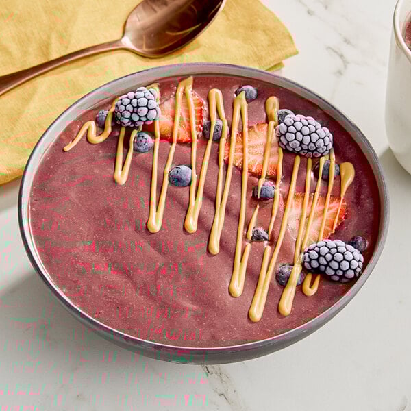 A bowl of Tropical Acai Scoopable Acai Sorbet with strawberries and blueberries.