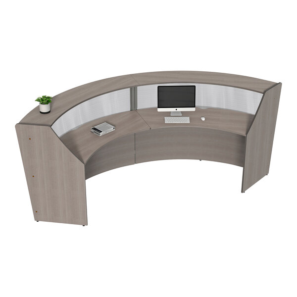 A Correll curved reception desk with a computer and keyboard on it.